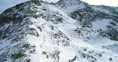 在冬天的雪山上，有登山滑雪者在登山。雪覆盖了山顶